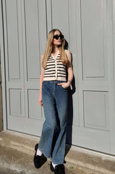 a lady wears a knitted vest with loose fit jeans